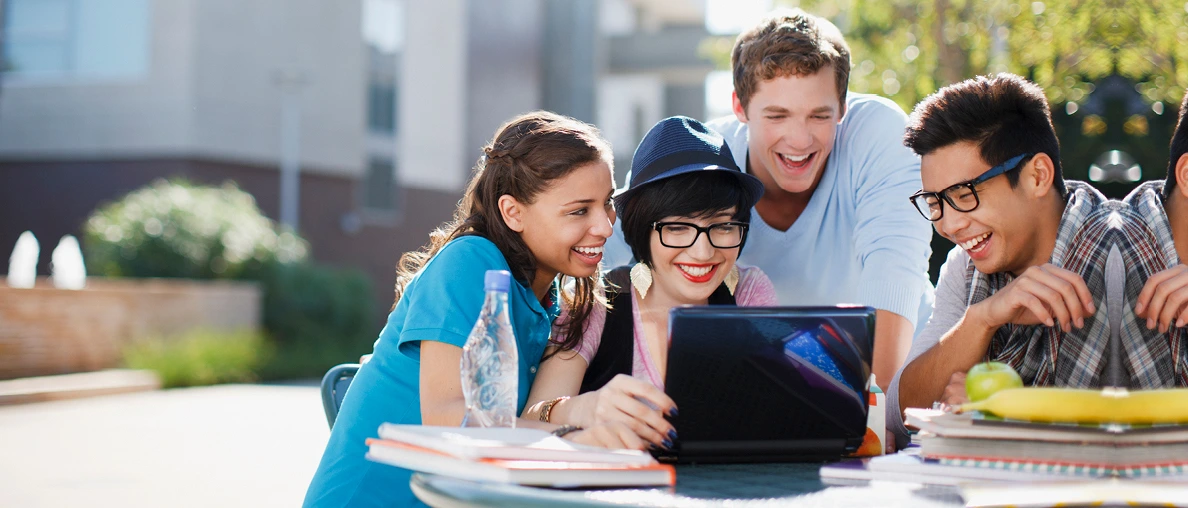 Students gather around a laptop